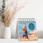 "53 Energieimpulse für Powerfrauen 2027." Ein Tischkalender zeigt eine Frau, die in einer weiten Landschaft springt.