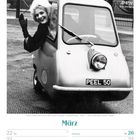 März 2027 Kalenderblatt mit einer Frau in einem Peel P50 Auto, winkend.