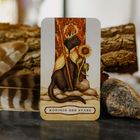 Text "Königin der Stäbe". Illustration einer schwarzen Katze mit Krone, Sonnenblume und Umhang vor einem dekorativen Hintergrund.