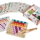 „Montessori by Educanda“. Das Bild zeigt bunte Kugeln sortiert auf einem Holzbrett und in Karten mit Farbmuster.