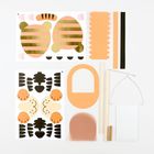 Bastelset mit bunten Papierformen: Tigerstreifen, Tiergesicht, Stäbe, Draht und Kleinteile zum Selbermachen.