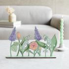 Eine pastellfarbene Blumenillustration mit Lilien und Lavendel, im Hintergrund ein Sofa und eine spiralförmige Kerze.