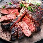 Ein saftig gebratenes Steak mit Kräutern garniert, in Scheiben geschnitten auf einem Teller serviert.