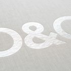 Die Buchstaben "O & O" sind in Weiß auf einem grauen strukturierten Hintergrund zu sehen.