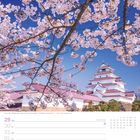 Text unten: "Burg Aizu-Wakamatsu während der Kirschblüte - Präfektur Fukushima". Ein Schloss hinter blühenden Kirschbäumen.