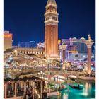 16. April: Eine nächtliche Szene mit hell beleuchtetem Turm, Kanal und Gondeln in einem Resort mit venezianischem Flair.