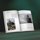 Offenes Buch mit Text über "Annemarie Maes" und Bilder von Skulpturen, vor dunklem, unscharfem Hintergrund.