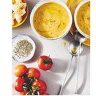 Seite 67. Zwei Schüsseln mit gelber Suppe, Olivenöl und Pfeffer, daneben Tomaten, Kräuter und Brotwürfel.