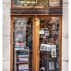 Text: "Livres, Métiers d'Art - Arts décoratifs, Achat de Livres". Eine antike Buchhandlung mit Holztür und Schaufenster.