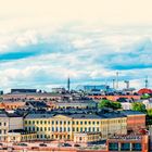 Text: "HELSINKI. Der Dom bestimmt die Skyline von Helsinki." Malerische Stadtszene mit bunten Gebäuden am Wasser.