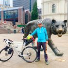„Oslo Sentralstasjon“ steht im Hintergrund. Ein Mann mit Helm und Fahrrad steht neben einer großen Tigerstatue.