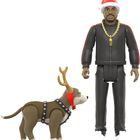 Ein Mann in Trainingsanzug mit goldener Kette trägt eine Weihnachtsmütze. Neben ihm steht ein Hund mit Rentiergeweih.