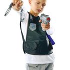 Ein Kind in Polizei-Weste mit dem Text "Polizei" hält Handschellen und eine Spielzeugpistole.