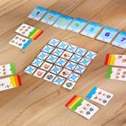 Karten mit Zahlen 1 bis 7, bunte Illustrationen von Tieren auf anderen Karten, auf einem Holztisch arrangiert.