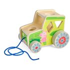 Der Text "HABA" befindet sich auf einem Spielzeugauto mit grünem Design und einer rosa Schwein-Illustration.
