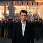 „Schütze die ökologische Umwelt, verwirkliche nachhaltige Entwicklung.“ Ein ernster Mann im Vordergrund, Gruppe im Hintergrund.