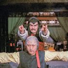 Vertikale asiatische Schriftzeichen links. Zwei Männer in asiatischen Kostümen mit dramatischen Posen.