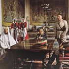 Keine sichtbaren Texte. Eine Gruppe von Männern in militärischer Kleidung und traditioneller arabischer Kleidung in einem prächtigen Raum.