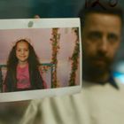 #NoLabel. Ein Mann hält ein Foto eines Mädchens mit Blumenkranz und Lächeln.