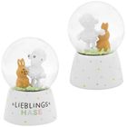 "LIEBLINGS HASE" steht auf einem weißen Sockel mit bunten Punkten. Oben sind Schaf und Hase in einer Schneekugel.