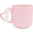 Rosa Tasse mit herzförmigem Griff, an dem ein Etikett mit abstrakten rosa Herzen hängt.