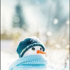 Februar 2027 Kalender. Zitat von Thomas Wolfe: "Das Vergnügen ist die Verpackung des Glücks." Schneemann mit Mütze.