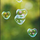 März 2027 Kalender. Text: "Glaub an dich - denn du kannst alles schaffen!" Herzförmige Seifenblasen vor unscharfem Hintergrund.