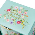 „Kleine Auszeit“ in goldener Schrift, umgeben von bunten Blumen auf einem türkisfarbenen Hintergrund.