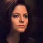Ich kann die Person nicht erkennen. Eine Frau mit kurzen braunen Haaren blickt nachdenklich. Sie trägt ein kariertes Sakko.