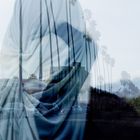 Verdoppelte Szene mit Palmen, Autos und Häusern, überlagert von durchscheinendem Stoff.