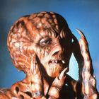 Ich sehe keine Texte. Ein Monster mit lederartiger Haut, großen Klauen und langen Zähnen vor blauem Hintergrund.