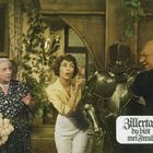 "Zillertal du bist mei' Freud'" steht in altmodischer Schrift. Drei Menschen stehen um eine Ritterrüstung in einem Raum.