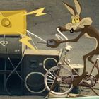Ein Comic-Wolf sitzt auf einem Fahrrad, hält eine Fernbedienung, daneben Lautsprecher und farbige Blitze.