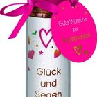 Pinkes Schild mit „Gute Wünsche zur Kommunion“. Glasflasche mit „Glück und Segen“. Rosa Vogel oben.