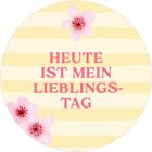 „HEUTE IST MEIN LIEBLINGS-TAG“ in rosa Schrift, gelb-weiß gestreifter Hintergrund, rosa Blüten verziert.