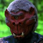 Ich kann den Text nicht lesen. Eine Kreatur mit einem großen roten Gesicht, einem Auge, Stoßzähnen und grauem Fell.