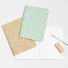 Keine erkennbaren Texte. Zwei Notizhefte mit floralen Mustern, ein Bleistift und ein Radiergummi.