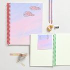 Notizbuch mit Text "THE SKY'S THE LIMIT", pastellfarbene Wolken, zwei Stifte, Anspitzer und Klebeband mit Wolkenmotiv.