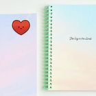 Text: "The Sky is the Limit". Zwei Spiralblöcke, einer mit Herz, Stifte, Radiergummi, sanfte Pastellfarben.