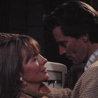 Keine erkennbaren Texte. Eine Frau und ein Mann stehen sich nahe, in einer dunklen Umgebung mit roter Lampe.