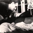 „Im Feuer der Lust“ steht auf einem Etikett. Ein Mann sitzt, blickt nach oben, während eine Frau ihn ansieht.