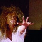 Es gibt keinen Text im Bild. Eine Person mit unordentlichen Haaren und verschmiertem Gesicht streckt die Hand aus.