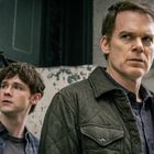 Zwei Männer schauen ernst in verschiedene Richtungen. Der Vordergrund zeigt einen Mann mit kurzem Haar in einer Jacke.