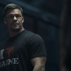 Text: "I ❤️ MAINE" mit einem Hummer. Ein muskulöser Mann in einem dunklen Raum, trägt ein schwarzes T-Shirt.