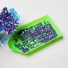 Lila Pailletten auf einem grünen Plastiktablett und in einer transparenten Plastiktüte.