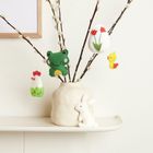 Filzanhänger in Form von Huhn, Frosch, Osterei mit Blumen, Küken an Zweigen, weiße Keramikvase, weißes Filzkaninchen.