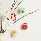 Keine Texte vorhanden. Vase mit Zweigen und Blumen, dekoriert mit bunten Eier-Anhängern. Ostermotive wie Hase und Blumen.