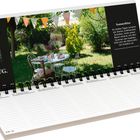 Kalender, Wochenübersicht im Juli/August, Foto eines Gartens mit Tisch, Stühlen, Wimpelketten. Text: "Sommerhitze".