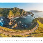 "2 • 2027". Serpentinweg über grünes Vorgebirge am Meer, Sonne von rechts.