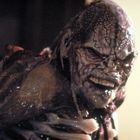 Keine erkennbaren Texte. Eine grotesk gestaltete Kreatur mit verformtem Gesicht und sichtbaren Adern.